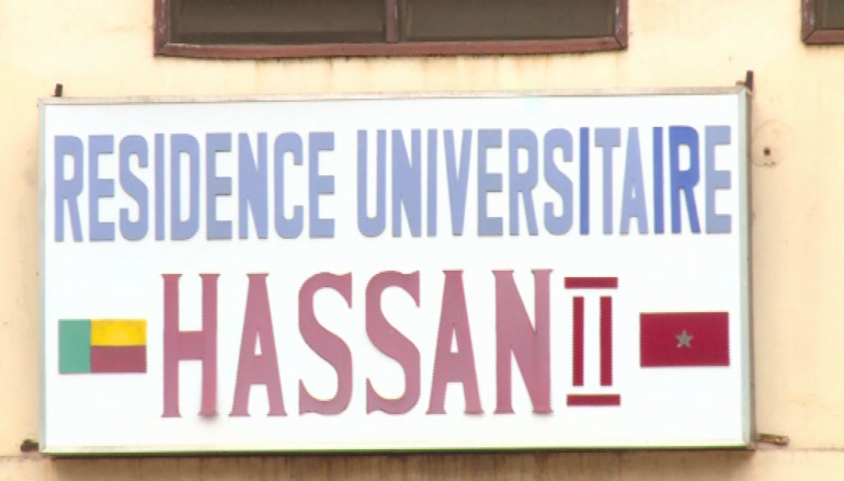 Panneau indiquant une résidence universitaire avec les drapeaux du Bénin et du Maroc sur une façade beige