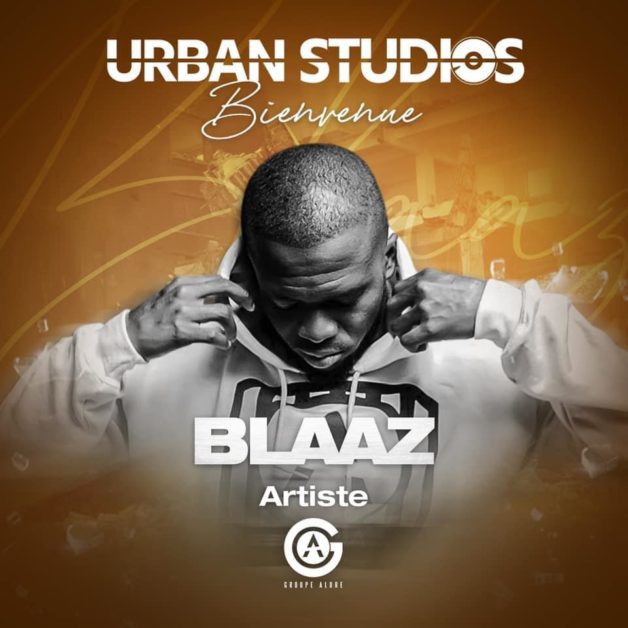 Homme en sweat à capuche baissé posant tête basse sur fond orangé avec texte URBAN STUDIOS Bienvenue BLAZ artiste