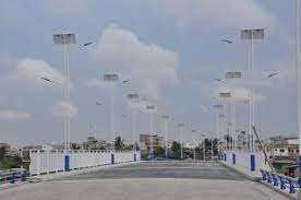Pont routier vide bordé de lampadaires le long d'une voie urbaine sous ciel nuageux