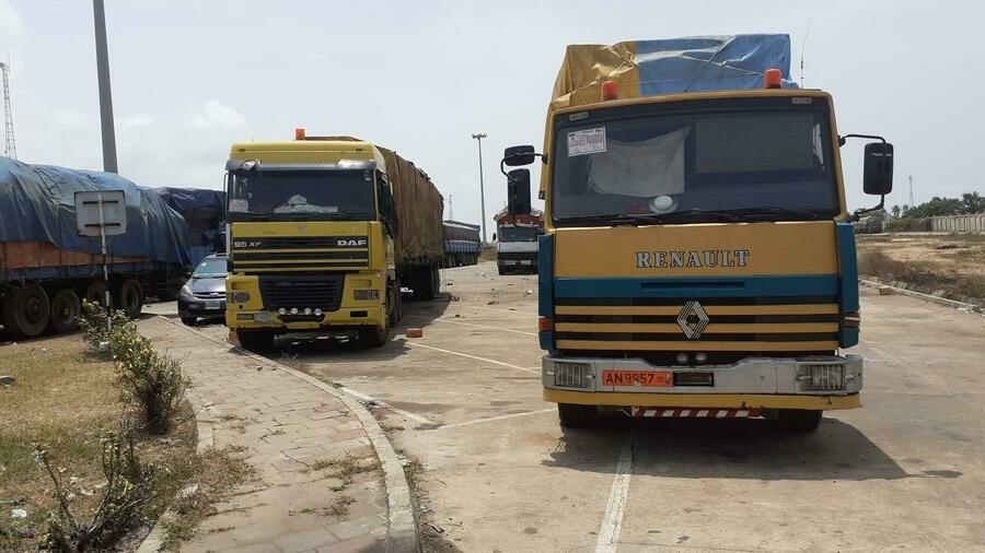 Deux camions poids lourds garés sur une aire de stationnement sous ciel clair