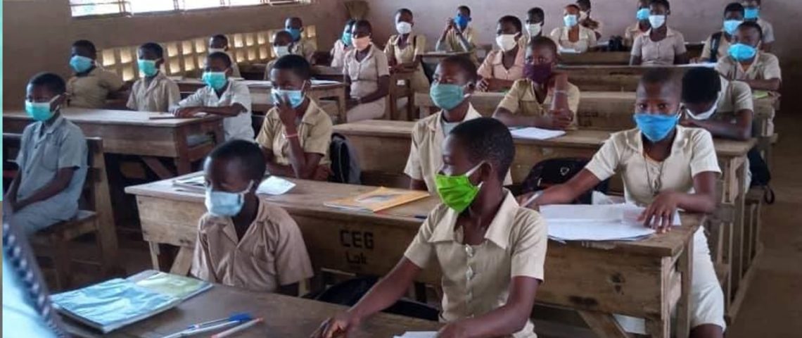 Des élèves assis à leurs bureaux dans une salle de classe respectent le port du masque sanitaire
