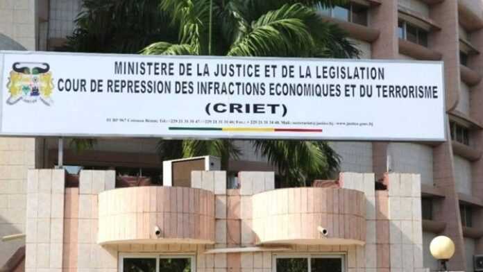 Entrée d’un bâtiment avec une grande enseigne indiquant ministère de la justice et législation, CRIET visible