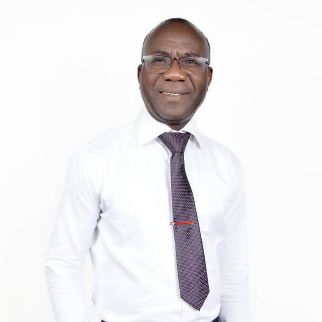 Homme souriant en chemise blanche et cravate avec lunettes devant un fond blanc uniforme