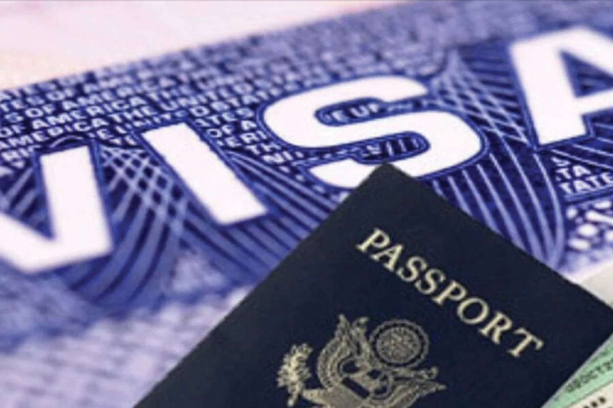 Passeport posé sur un document contenant en gros le mot visa en lettres blanches sur fond bleu