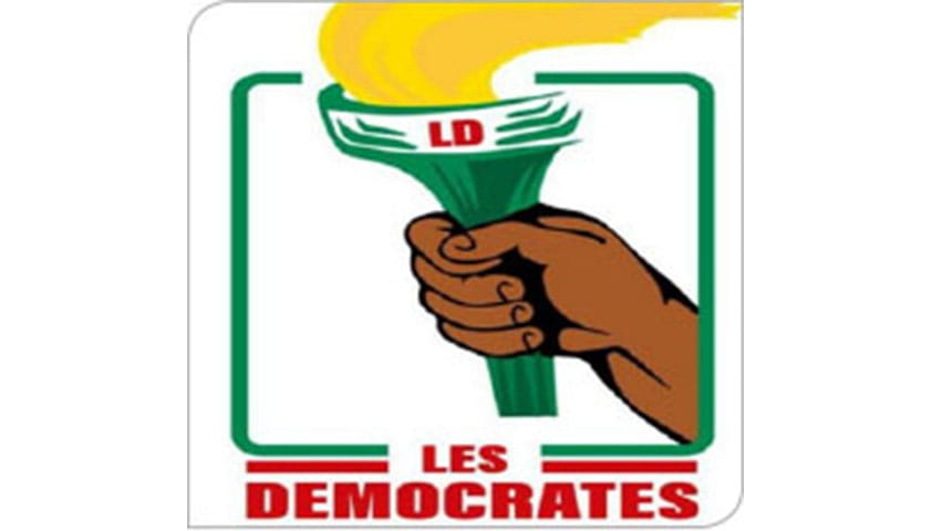 Logo avec une main tenant une torche allumée et les mots LES DEMOCRATES en rouge sur fond blanc