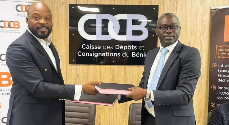 Deux hommes en costume échangent des dossiers devant un panneau indiquant la Caisse des Dépôts et Consignations du Bénin