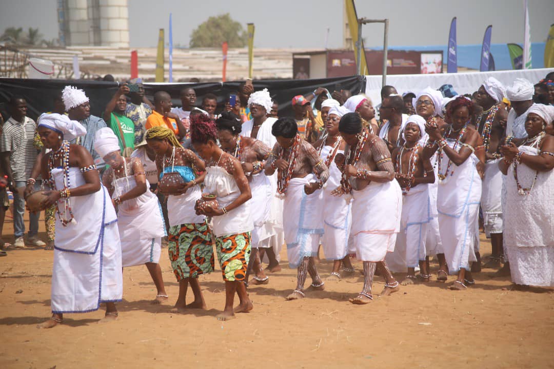 Groupe de femmes en tenues traditionnelles blanches dansant et participant à une cérémonie rituelle en plein air