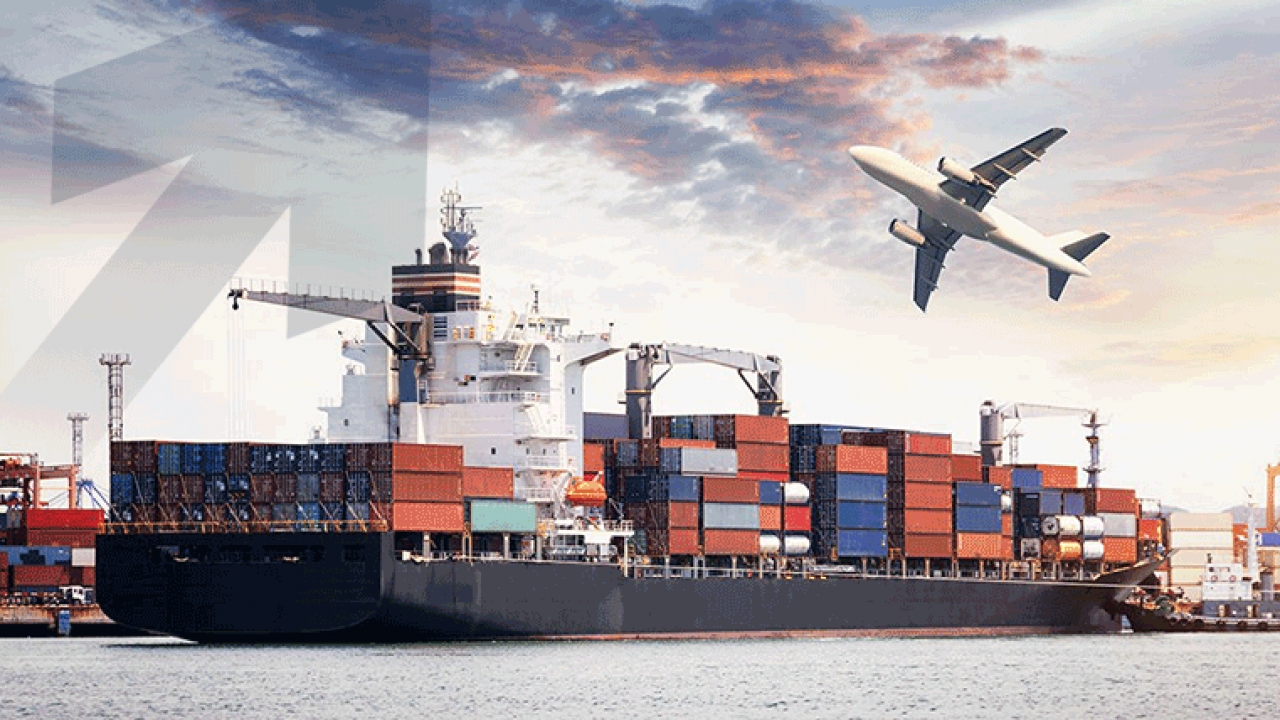 Cargo maritime chargé de conteneurs à quai avec un avion en vol au-dessus dans un ciel nuageux au coucher du soleil
