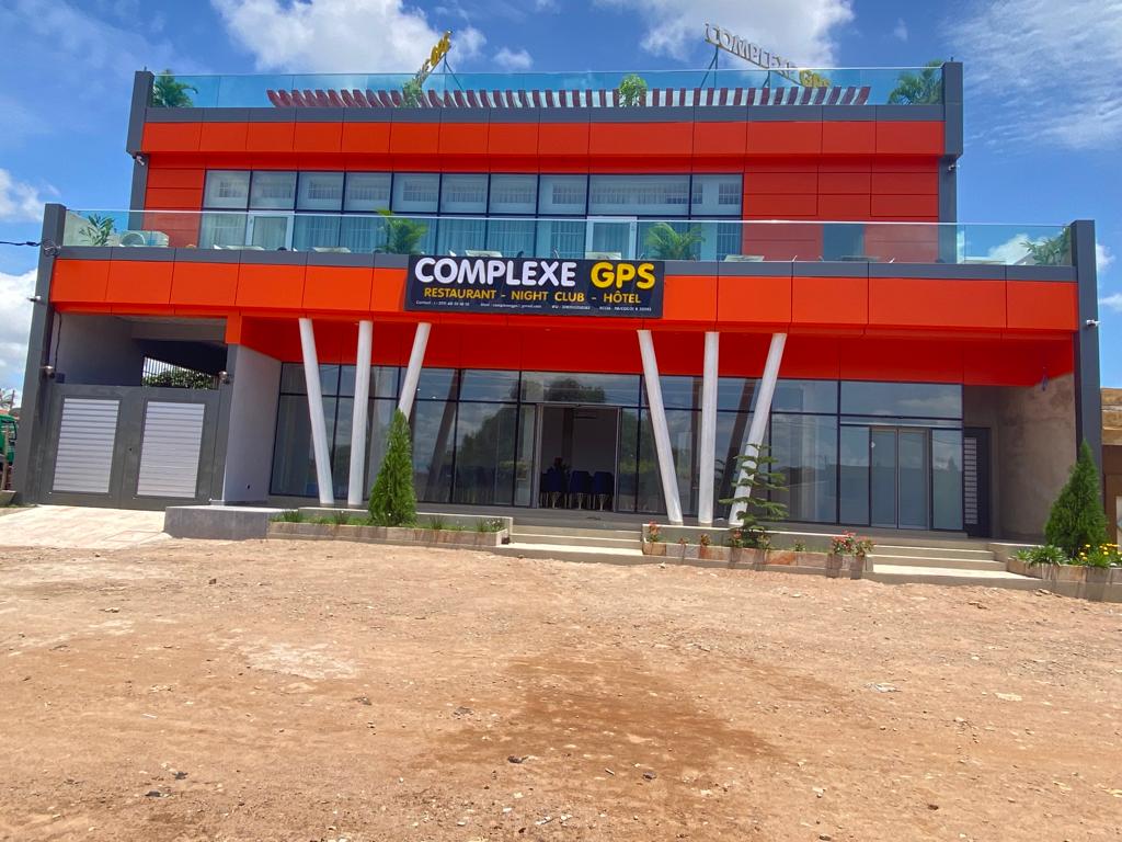 Façade moderne d un bâtiment commercial de trois étages avec enseigne complex GPS sous un ciel bleu partiellement nuageux