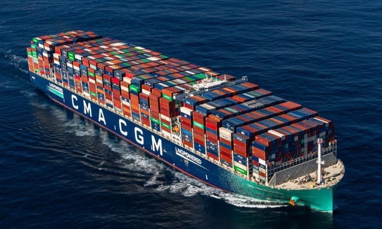 Grand porte-conteneurs bleu chargé de nombreux conteneurs multicolores naviguant en pleine mer