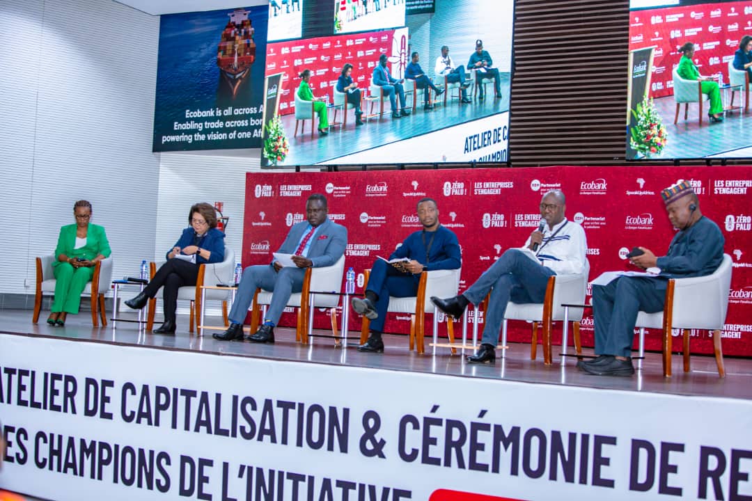 Six personnes assises sur une scène lors d un atelier avec un grand écran et un panneau rouge en arrière-plan