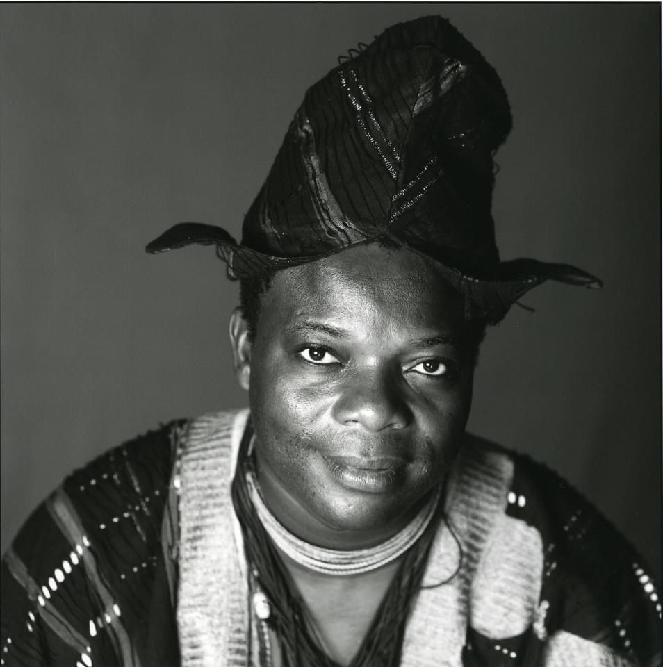 Portrait en noir et blanc d’un homme portant un bonnet traditionnel et une tenue à motifs ethniques