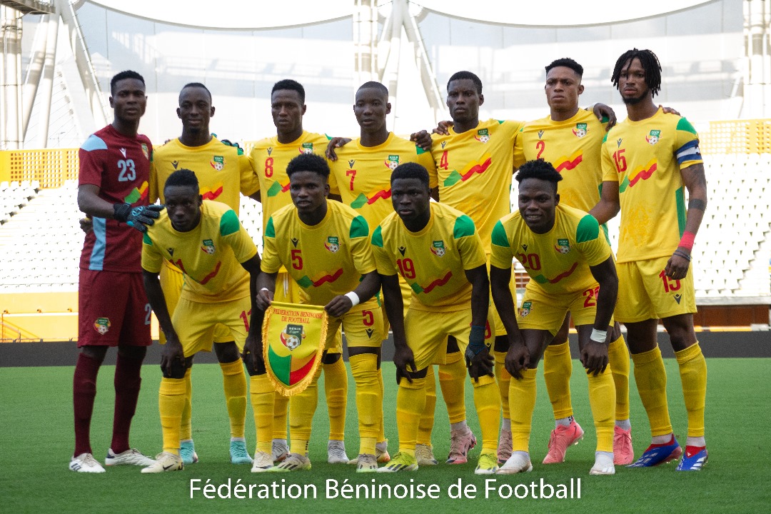 Onze joueurs vêtus de maillots jaunes posent sur le terrain d’un stade avant une rencontre de football