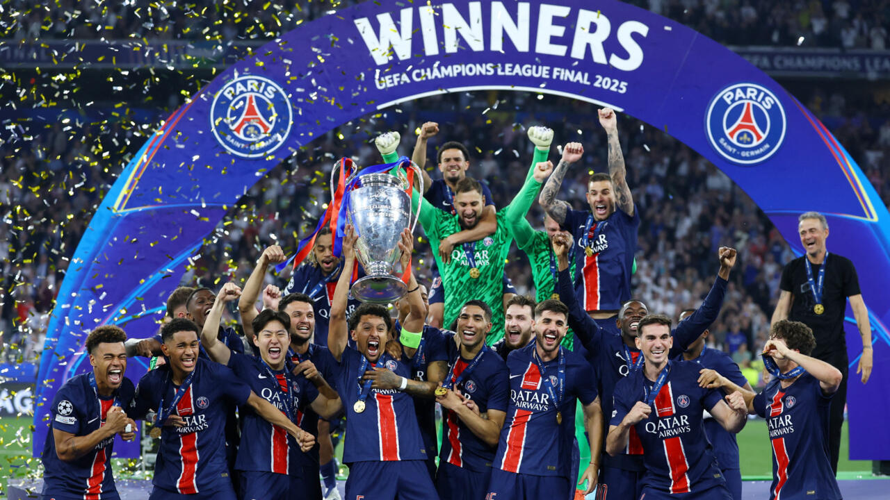 Une équipe de football célèbre avec un trophée sous une arche "WINNERS UEFA CHAMPIONS LEAGUE FINAL 2025" entourée de confettis et de fans