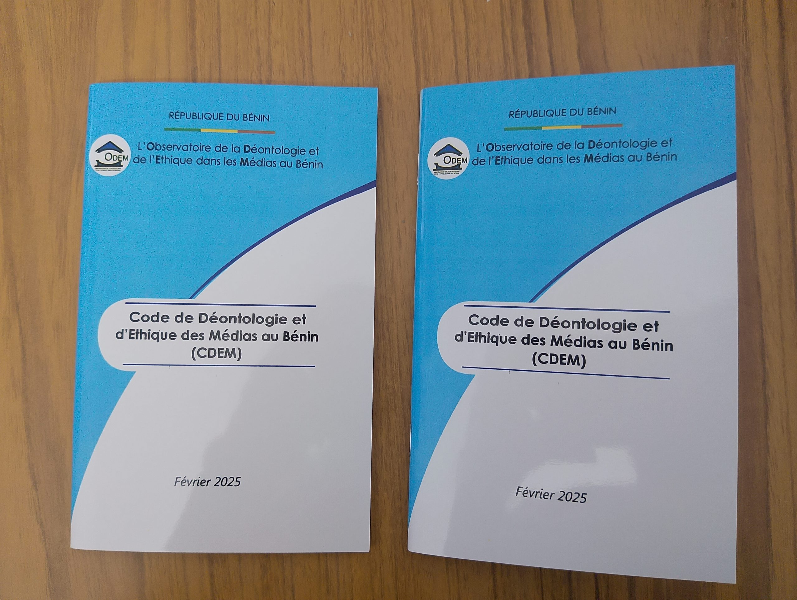 Deux exemplaires imprimés du Code de Déontologie et d’Éthique des Médias au Bénin posés sur une surface en bois