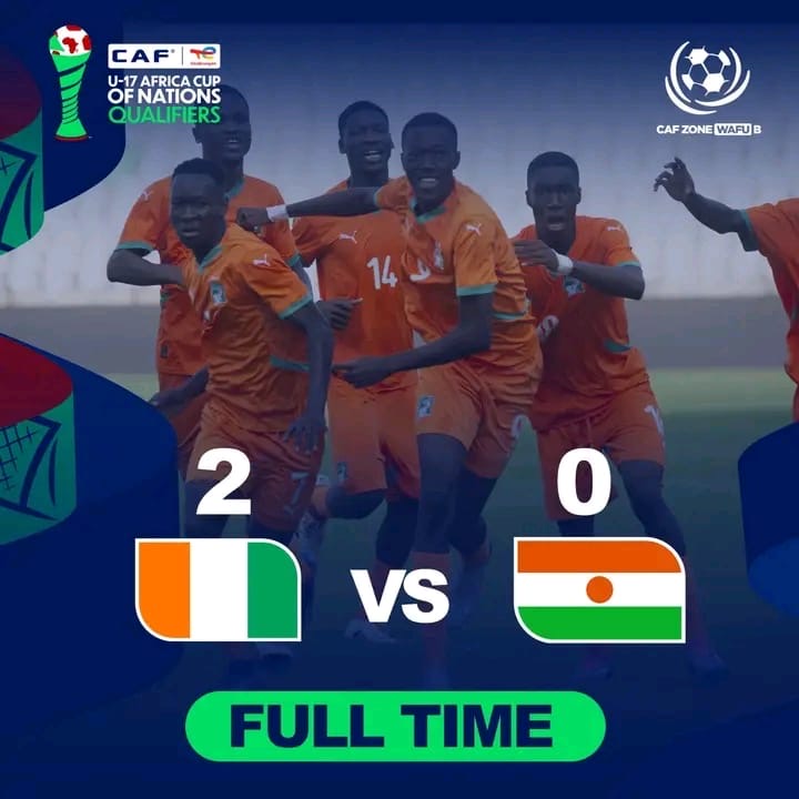 Joueurs de football adolescents en maillots orange célébrant un but sur le terrain avec score 2-0 affiché à l’écran
