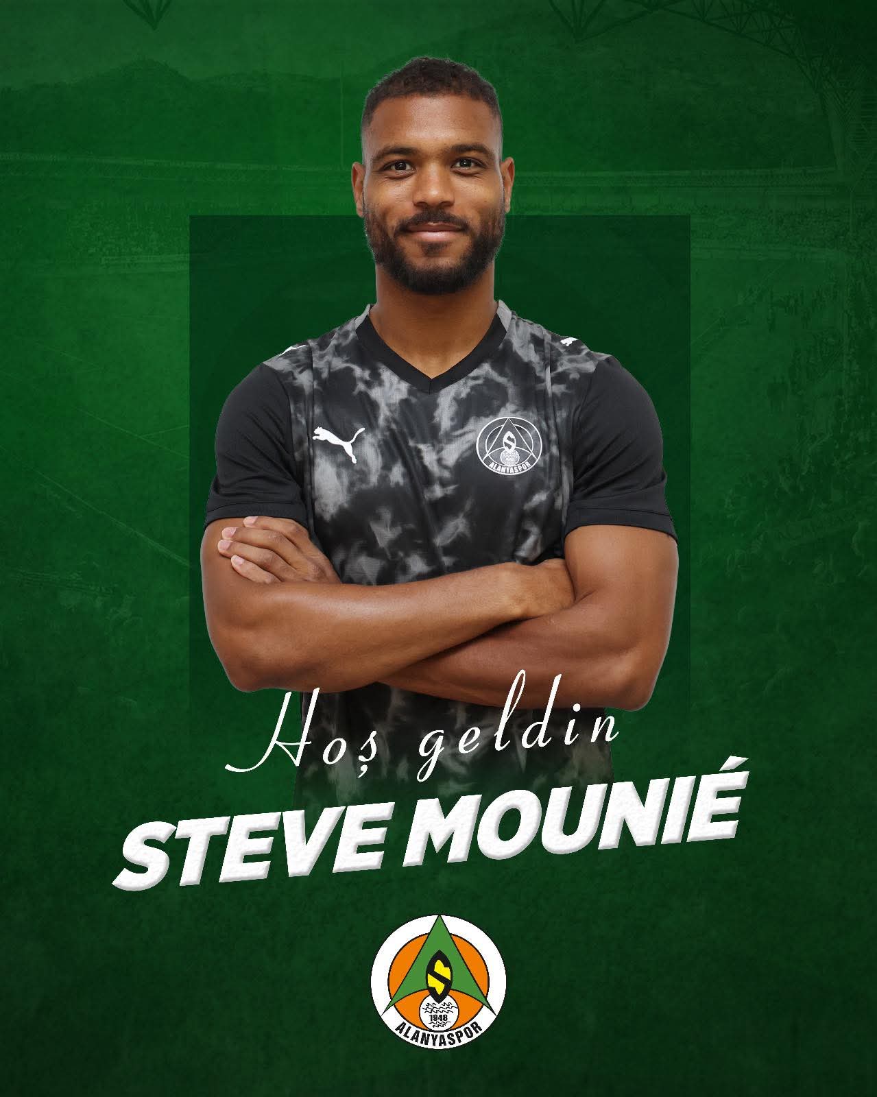 Homme souriant en maillot de sport noir avec logo posé bras croisés devant fond vert avec texte et logo d'équipe