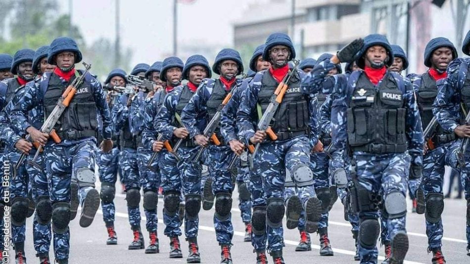 Des agents en uniformes bleu camouflage et gilets pare-balles défilent en rang lors d'une parade militaire