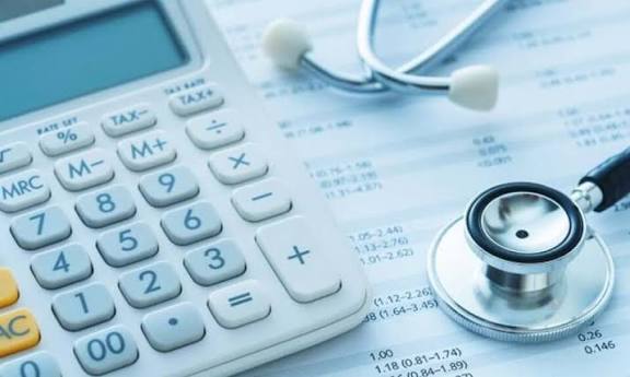 Une calculatrice et un stéthoscope posés sur un document financier détaillant des chiffres et des pourcentages