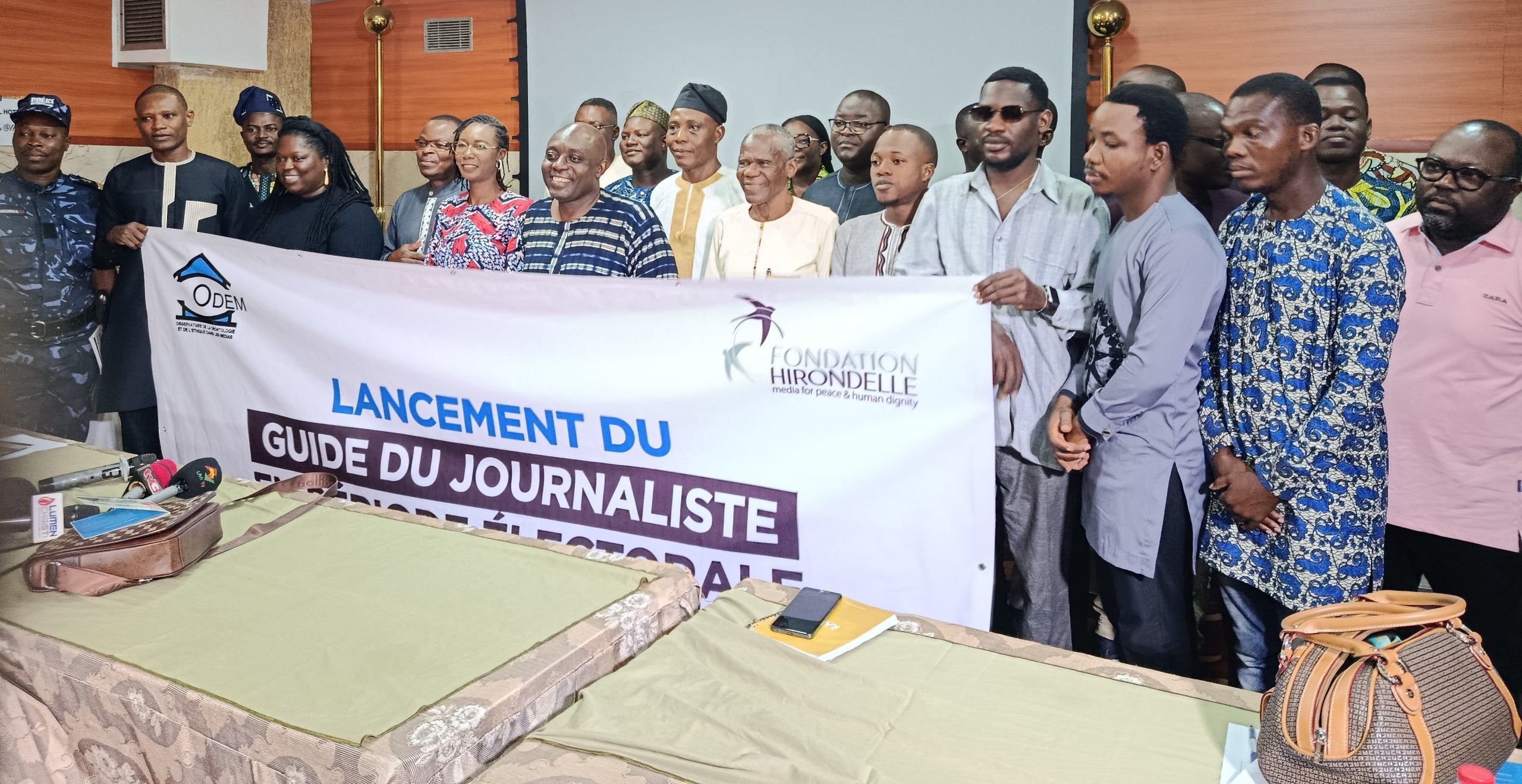 Groupe de personnes alignées tenant une grande bannière annonçant le lancement d un guide du journaliste en période électorale