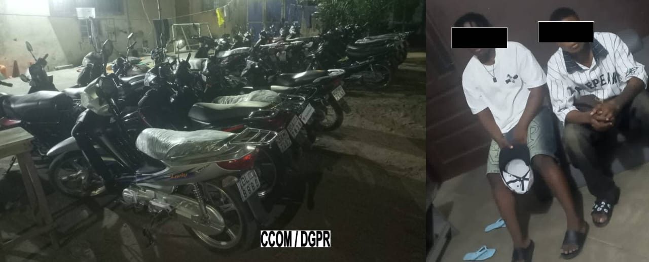 Deux adolescents assis, visage masqué, à côté de plusieurs motos stationnées la nuit dans un espace extérieur