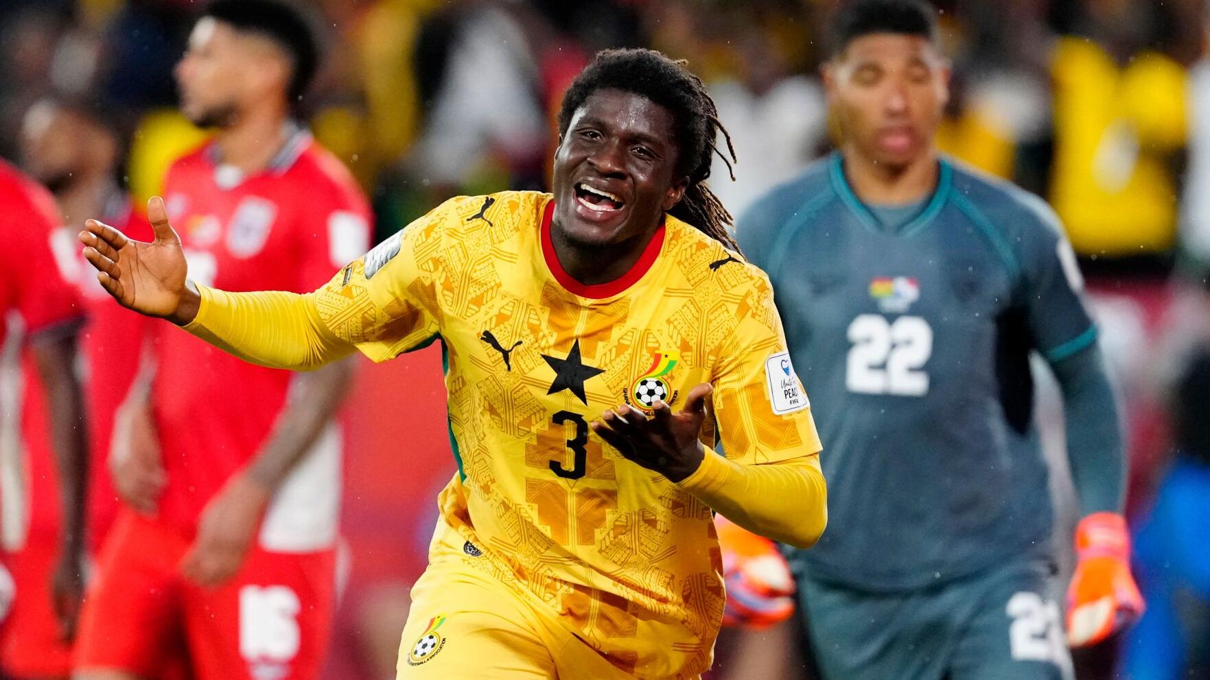 Un joueur en maillot jaune célèbre un but tandis que des adversaires en rouge et un gardien en gris restent en arrière