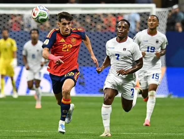 Deux joueurs de football courent après le ballon pendant un match intense sur le terrain.