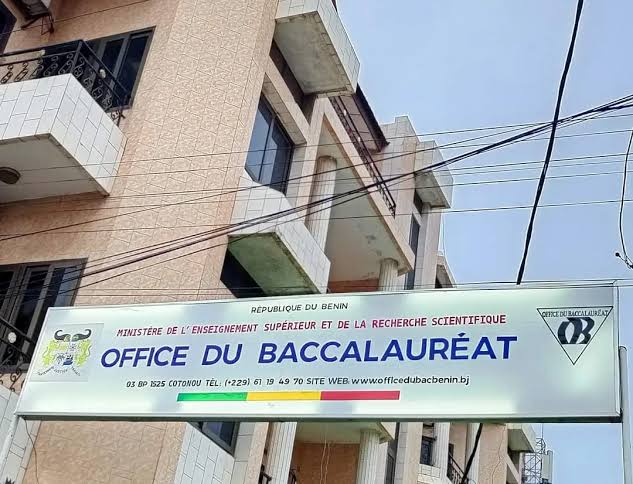 Panneau accroché sous un immeuble avec l'inscription Office du Baccalauréat et coordonnées de contact